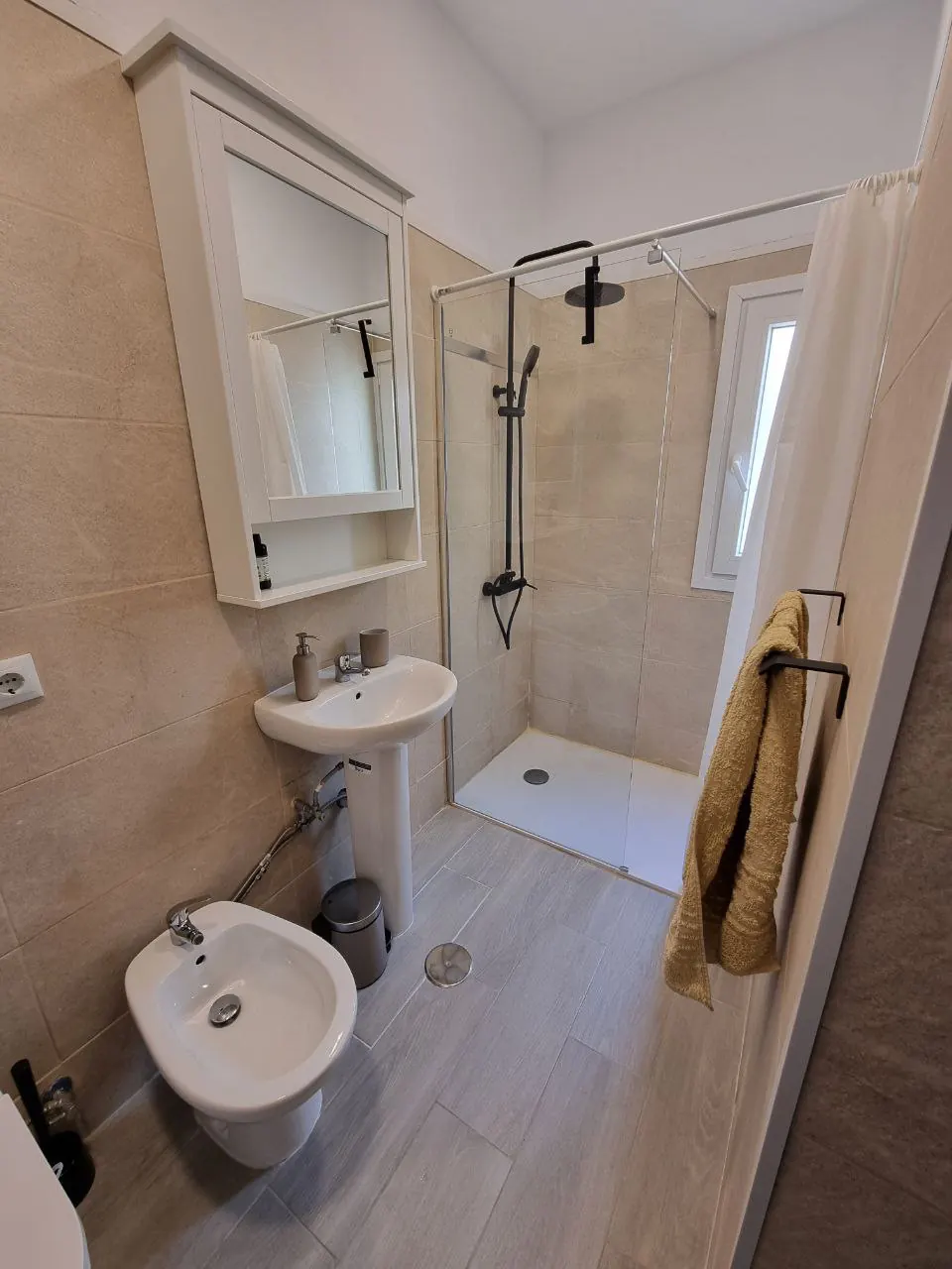 Baño con ducha, lavabo y espejo