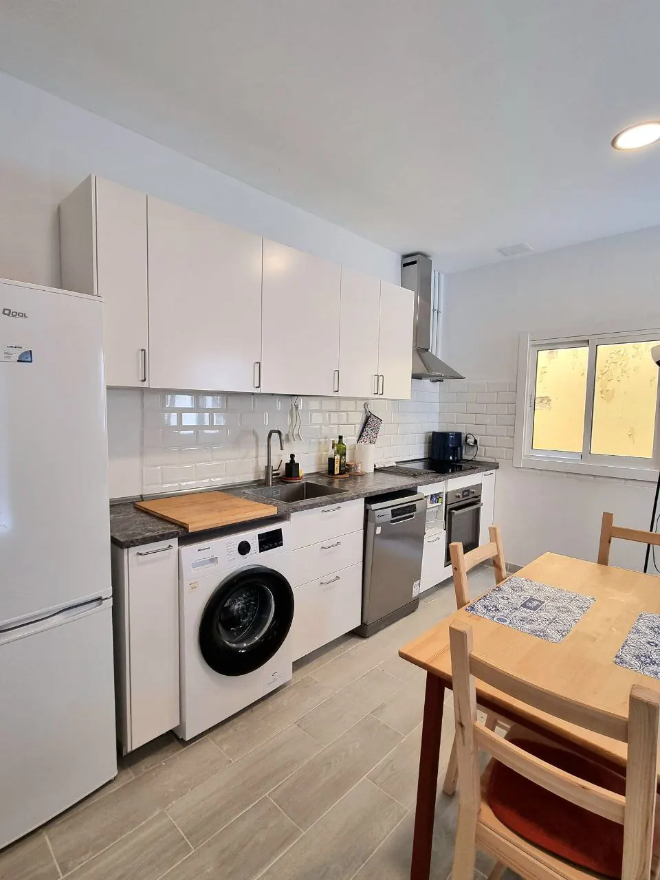 Cocina compartida con lavadora, lavavajillas, horno y mesa de comedor